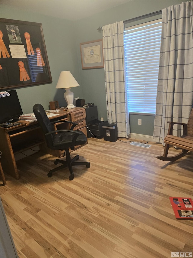 home office with visible vents and wood finished floors