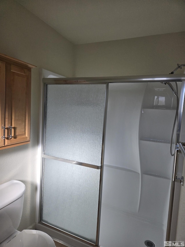 full bathroom with a shower stall and toilet