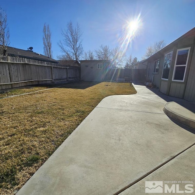 view of yard featuring a patio area, an outdoor structure, and a fenced backyard