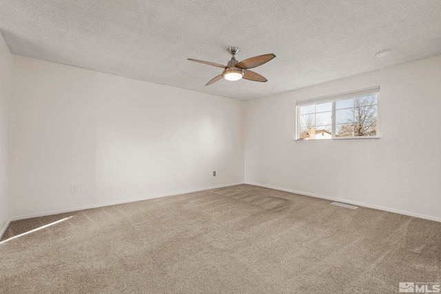 spare room with carpet flooring, a textured ceiling, and ceiling fan