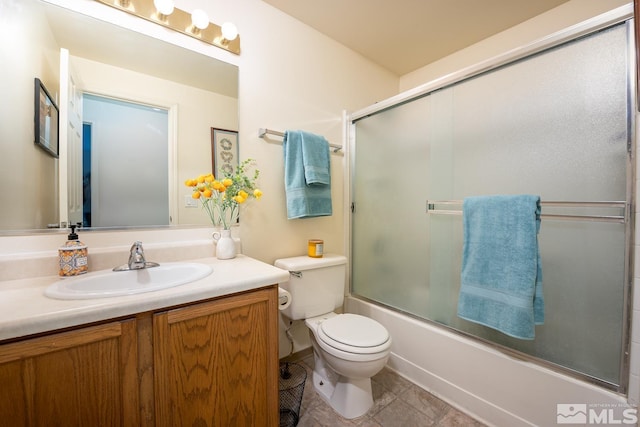 full bathroom featuring tile patterned floors, vanity, combined bath / shower with glass door, and toilet