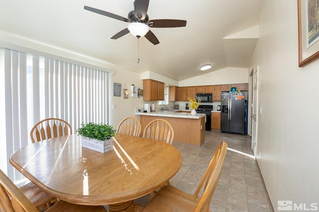 dining area featuring vaulted ceiling, ceiling fan, and sink