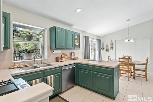 kitchen featuring tile counters, dishwasher, sink, kitchen peninsula, and vaulted ceiling