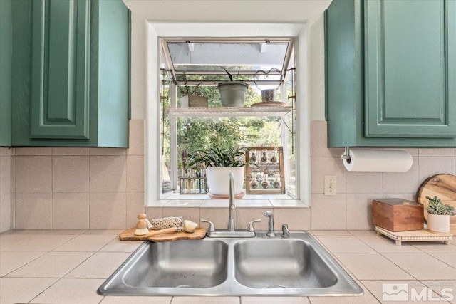 kitchen featuring green cabinets, sink, and tasteful backsplash