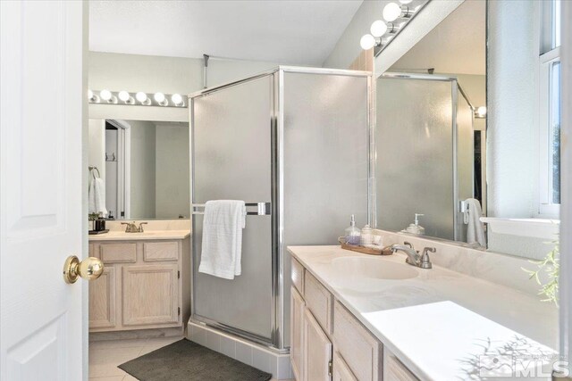 bathroom featuring tile patterned flooring, vanity, and walk in shower