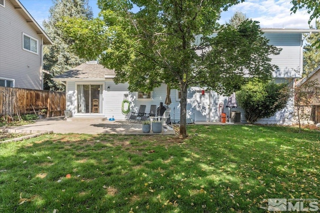 back of house featuring a lawn and a patio