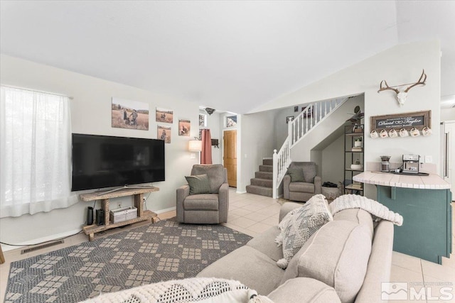 living room featuring light tile patterned floors and vaulted ceiling