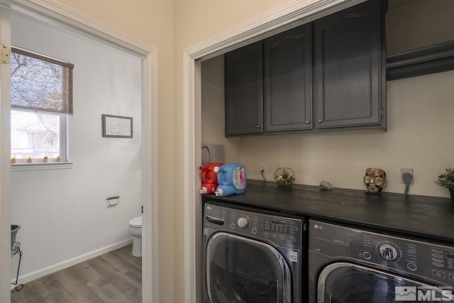 laundry room with washer and dryer, hardwood / wood-style flooring, and cabinets