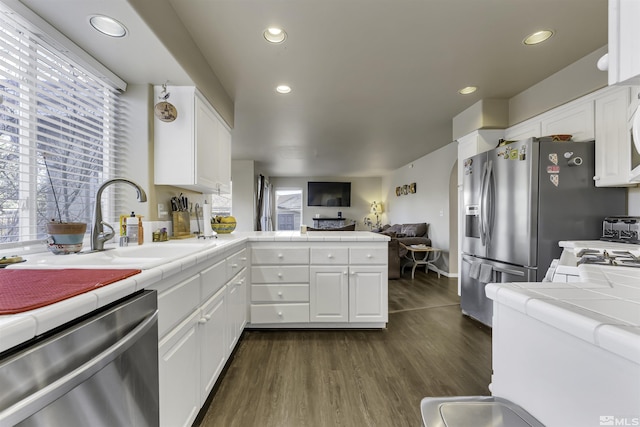 kitchen with tile counters, white cabinets, dark hardwood / wood-style floors, and appliances with stainless steel finishes