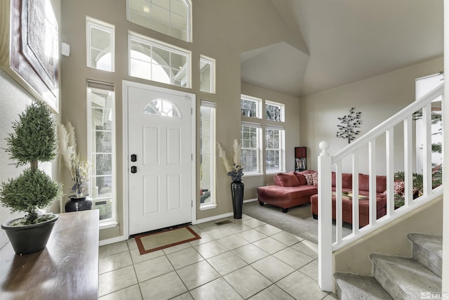 entryway featuring light tile patterned floors and a high ceiling