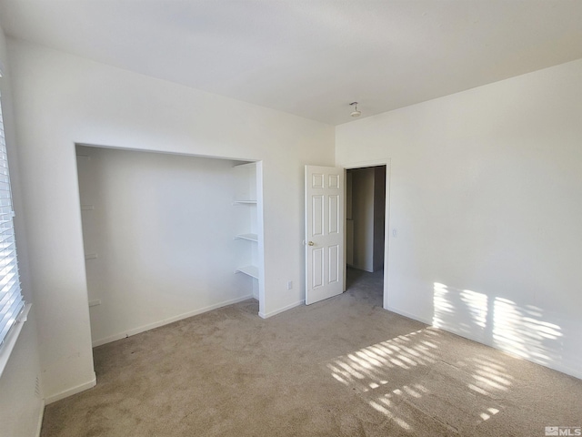 unfurnished bedroom with light carpet and a closet