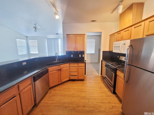 kitchen featuring track lighting, sink, light hardwood / wood-style flooring, ceiling fan, and appliances with stainless steel finishes