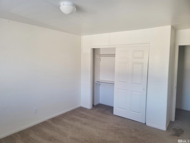 unfurnished bedroom with light carpet and a closet