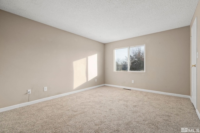 carpeted spare room featuring a textured ceiling