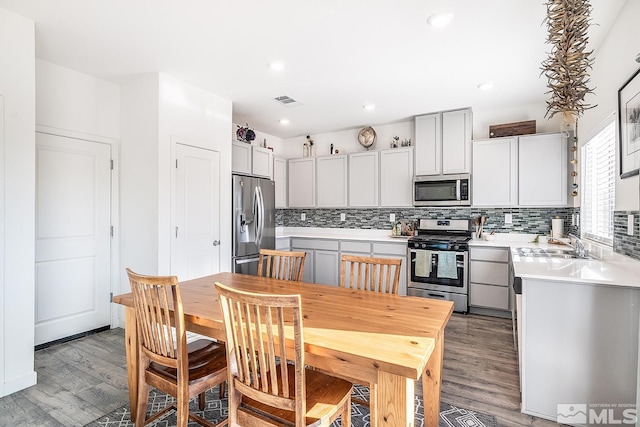 kitchen with sink, stainless steel appliances, tasteful backsplash, light hardwood / wood-style flooring, and gray cabinets