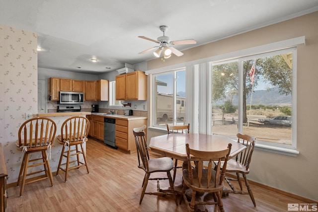 dining area featuring ceiling fan, a wealth of natural light, and light hardwood / wood-style flooring