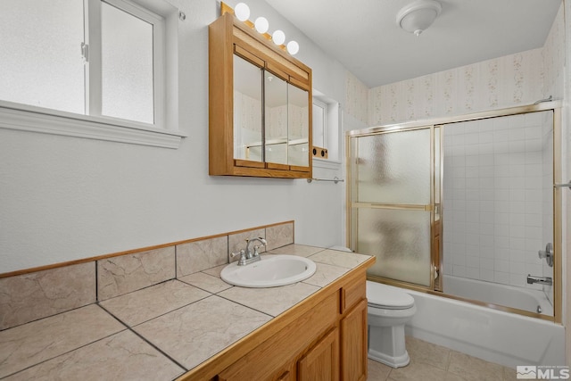 full bathroom with shower / bath combination with glass door, vanity, tile patterned flooring, and toilet