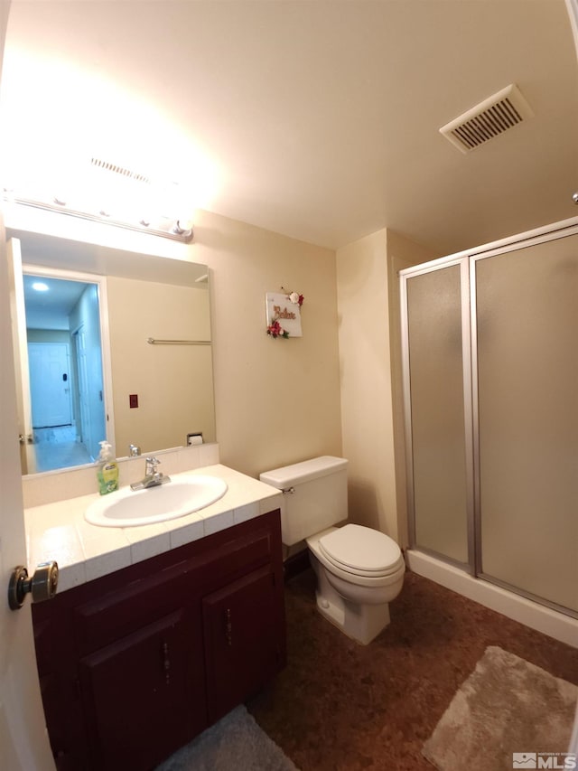 bathroom with vanity, toilet, and an enclosed shower