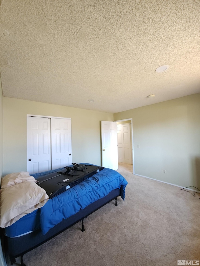 carpeted bedroom with a textured ceiling and a closet