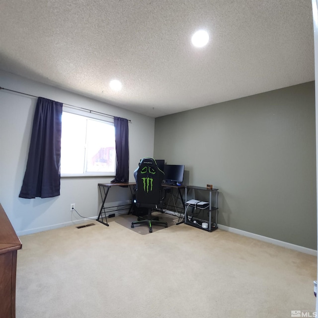 carpeted office featuring a textured ceiling