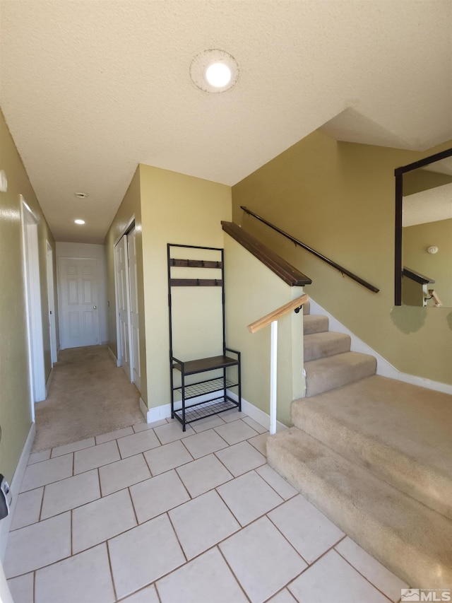 stairs featuring carpet and a textured ceiling