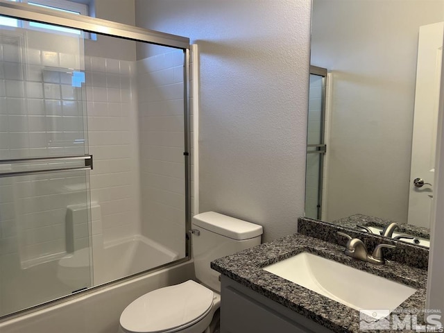 full bathroom featuring vanity, toilet, and shower / bath combination with glass door