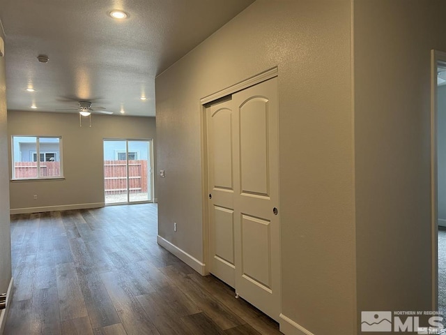 corridor with dark wood-type flooring and a textured ceiling