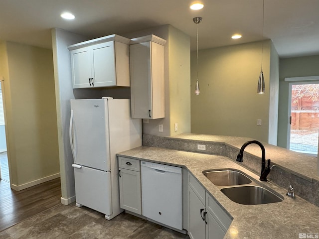 kitchen with white cabinetry, sink, dark hardwood / wood-style flooring, decorative light fixtures, and white appliances