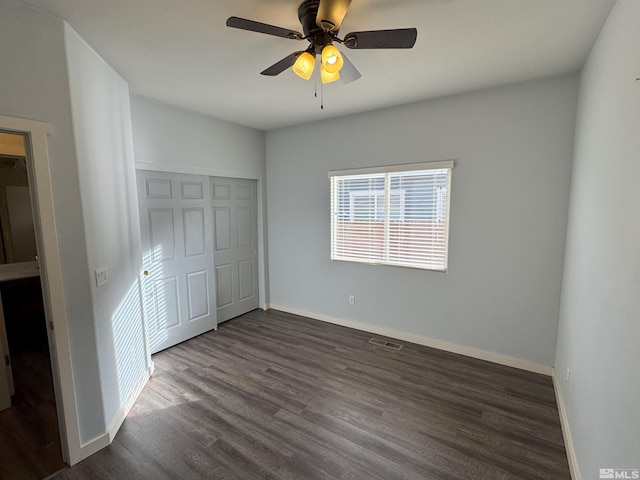 unfurnished bedroom featuring ceiling fan, dark hardwood / wood-style flooring, and a closet