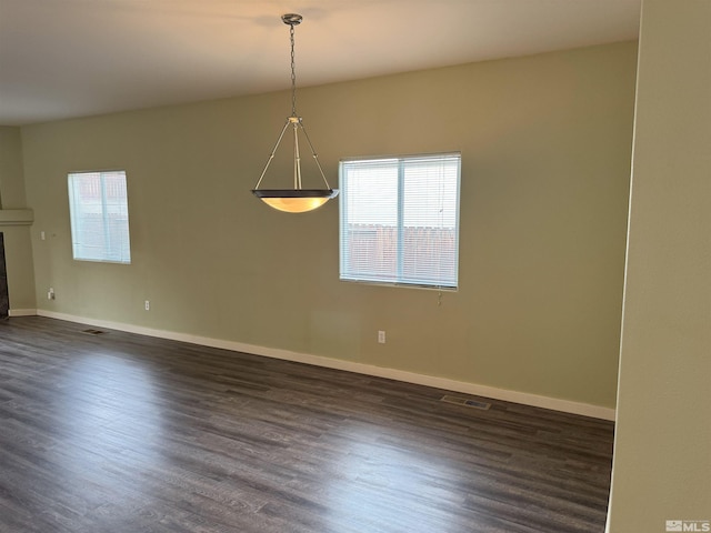 unfurnished room with a tile fireplace and dark hardwood / wood-style floors