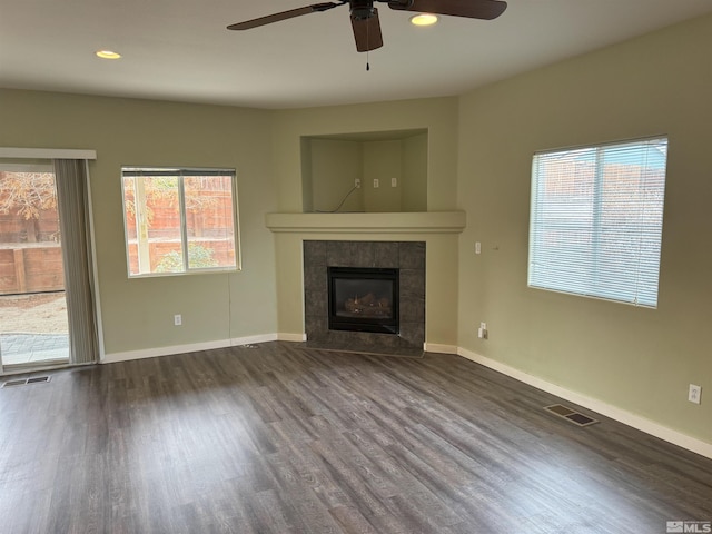 unfurnished living room with ceiling fan, a fireplace, and dark hardwood / wood-style floors