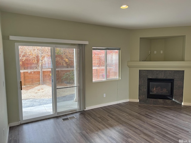 unfurnished living room with a fireplace and dark hardwood / wood-style flooring