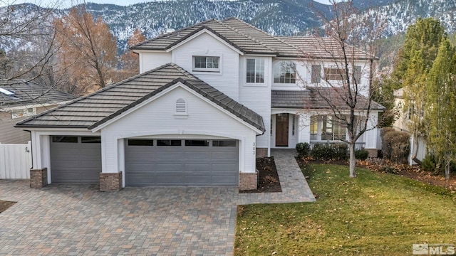 view of front property with a mountain view, a garage, and a front yard