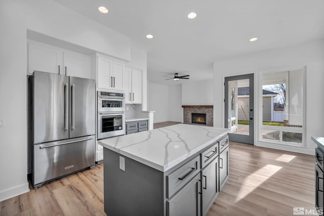 kitchen featuring gray cabinetry, a center island, white cabinets, and appliances with stainless steel finishes