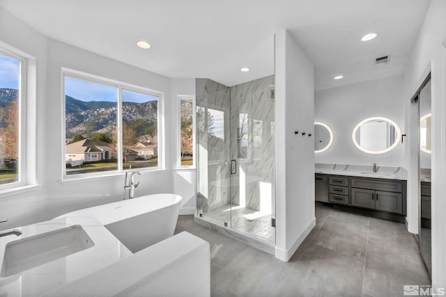 bathroom with a mountain view, shower with separate bathtub, and vanity