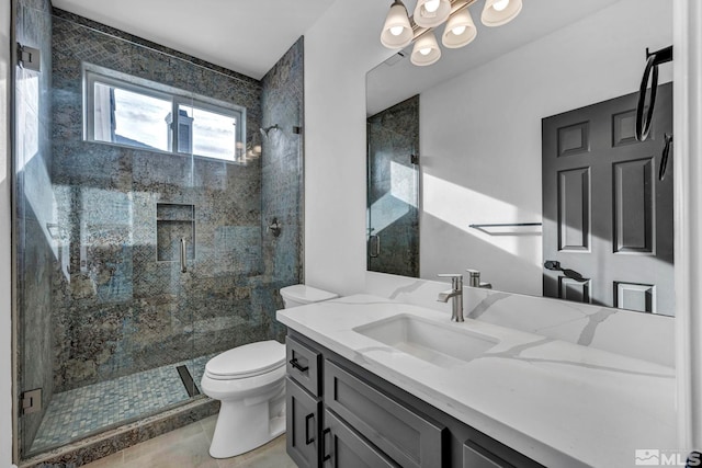 bathroom with tile patterned flooring, a shower with door, vanity, and toilet