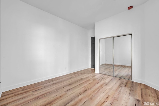 unfurnished bedroom featuring light hardwood / wood-style floors and a closet