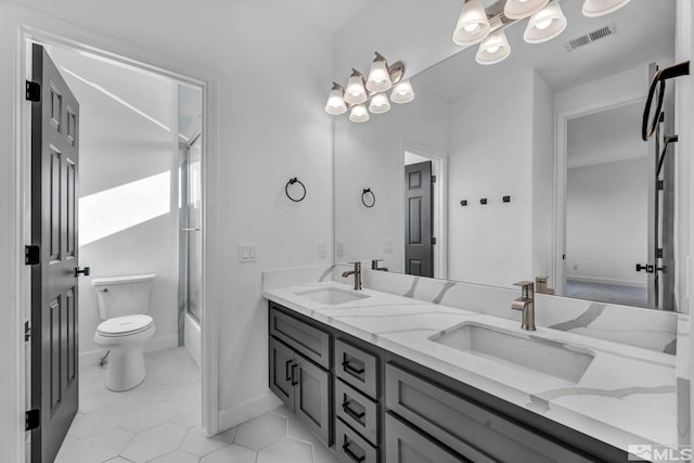 full bathroom with tile patterned floors, vanity, toilet, and shower / bath combination with glass door