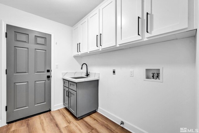 laundry area with cabinets, washer hookup, electric dryer hookup, sink, and light hardwood / wood-style flooring