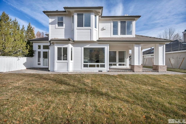 rear view of property featuring a patio and a lawn