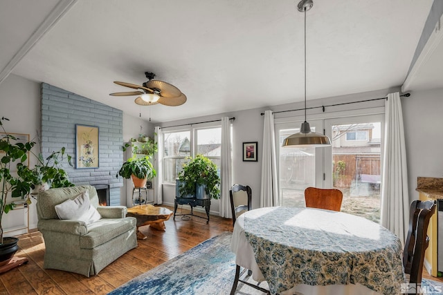 dining area with ceiling fan, hardwood / wood-style floors, and vaulted ceiling