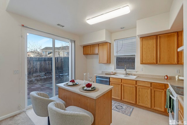 kitchen with a kitchen bar, stainless steel appliances, a kitchen island, and sink