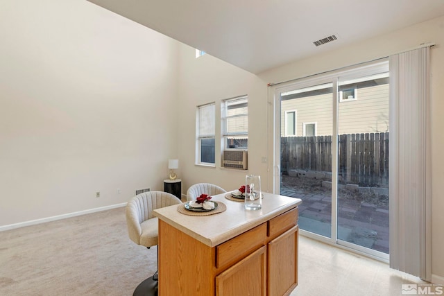 kitchen featuring a kitchen island and light colored carpet