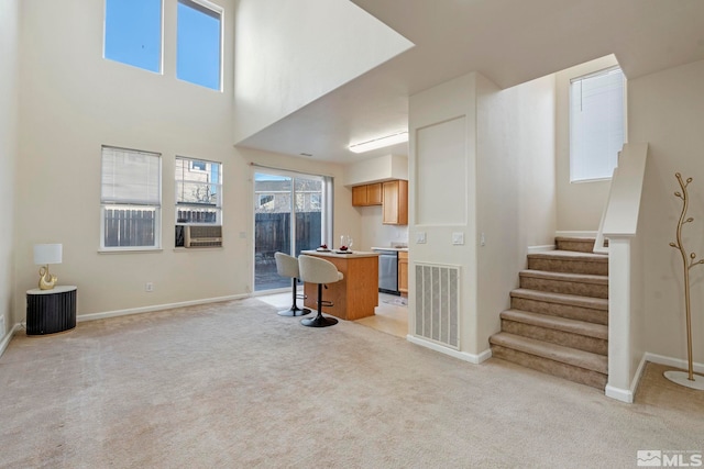 carpeted living room featuring a towering ceiling