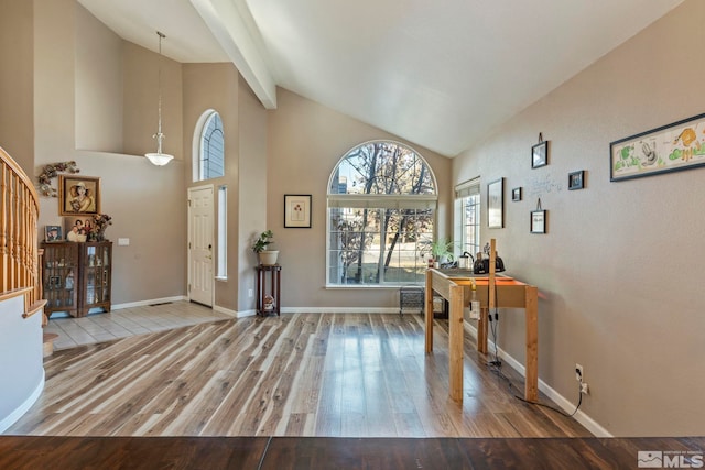 entryway featuring light hardwood / wood-style flooring and lofted ceiling with beams