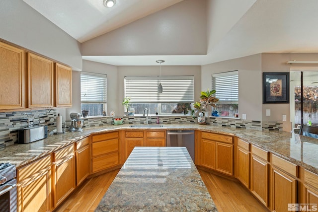 kitchen with appliances with stainless steel finishes, backsplash, sink, light hardwood / wood-style floors, and lofted ceiling