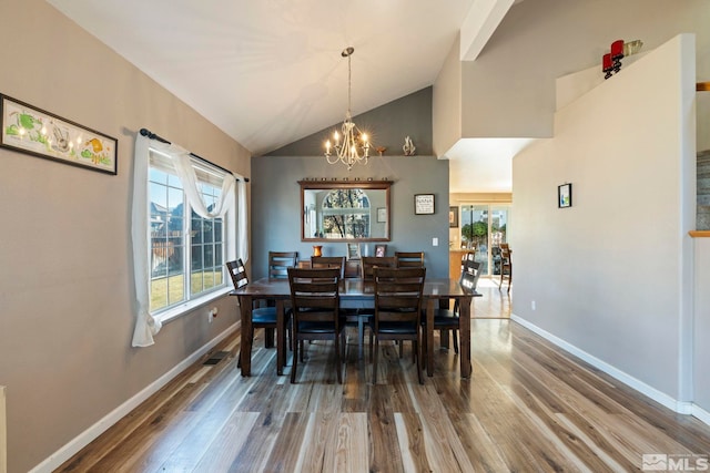 dining space featuring hardwood / wood-style floors, high vaulted ceiling, and a notable chandelier