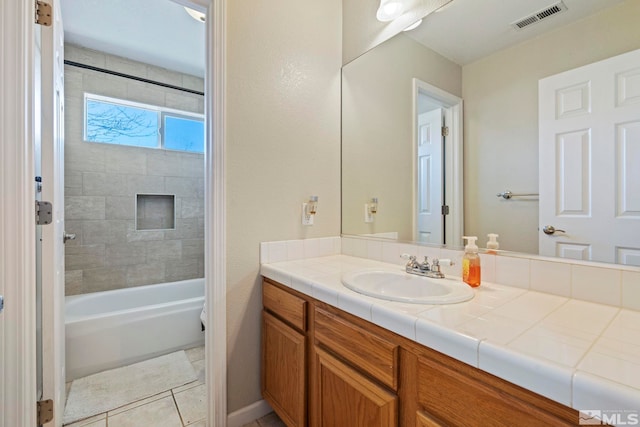 bathroom featuring tile patterned floors, vanity, and tiled shower / bath