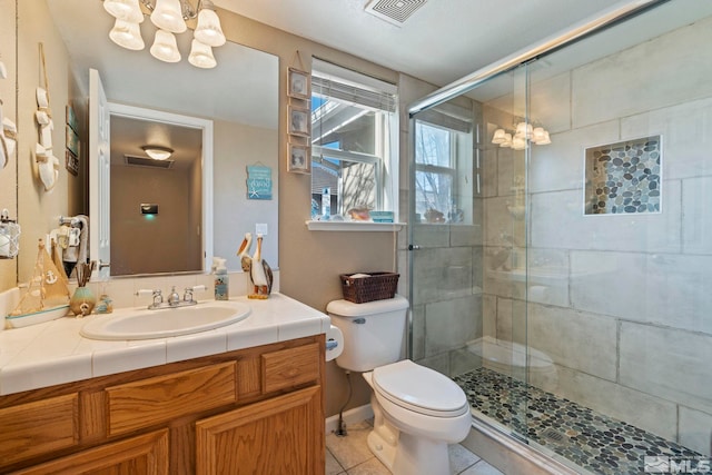 bathroom featuring walk in shower, tile patterned flooring, a notable chandelier, toilet, and vanity