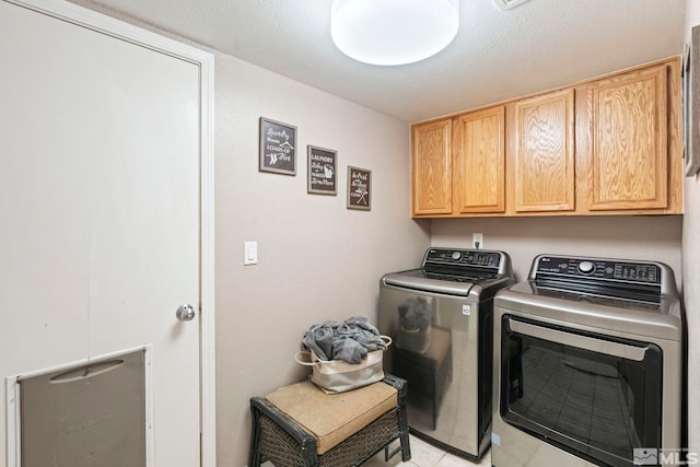 clothes washing area featuring cabinets, independent washer and dryer, and a textured ceiling